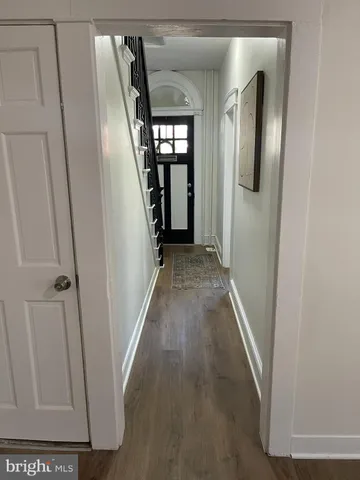 a view of a hallway with wooden floor and staircase