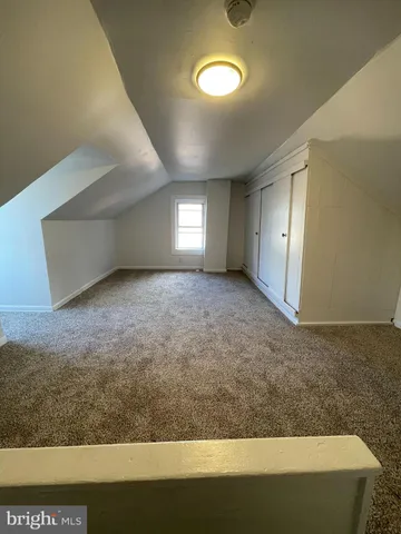 a view of an empty room with window and chandelier fan