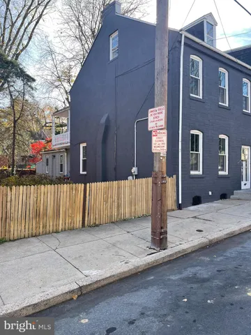 a white house that has tree in front of it