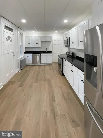 a large kitchen with granite countertop a large counter top stainless steel appliances and cabinets