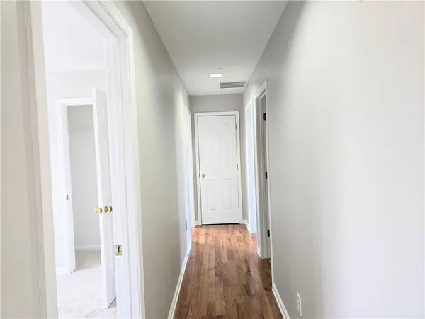 a view of a hallway with wooden floor