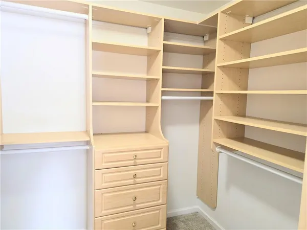 a view of walk in closet with empty racks