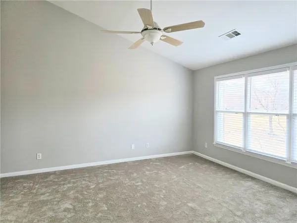 an empty room with a window and a fan