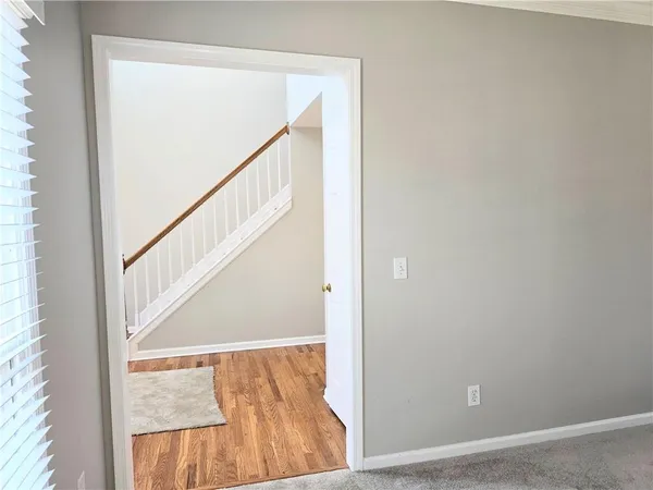 a view of staircase with railing and white walls