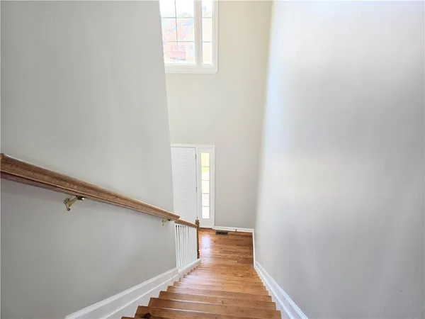 a view of a hallway with wooden floor and staircase