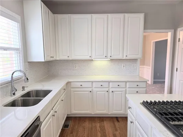 a kitchen with granite countertop a sink stove and cabinets