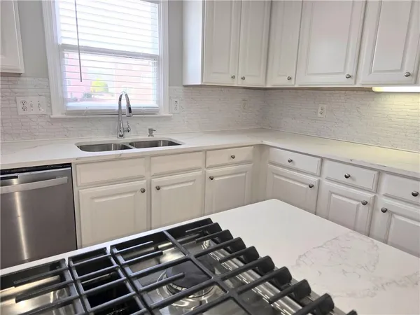 a kitchen with white cabinets and a stove
