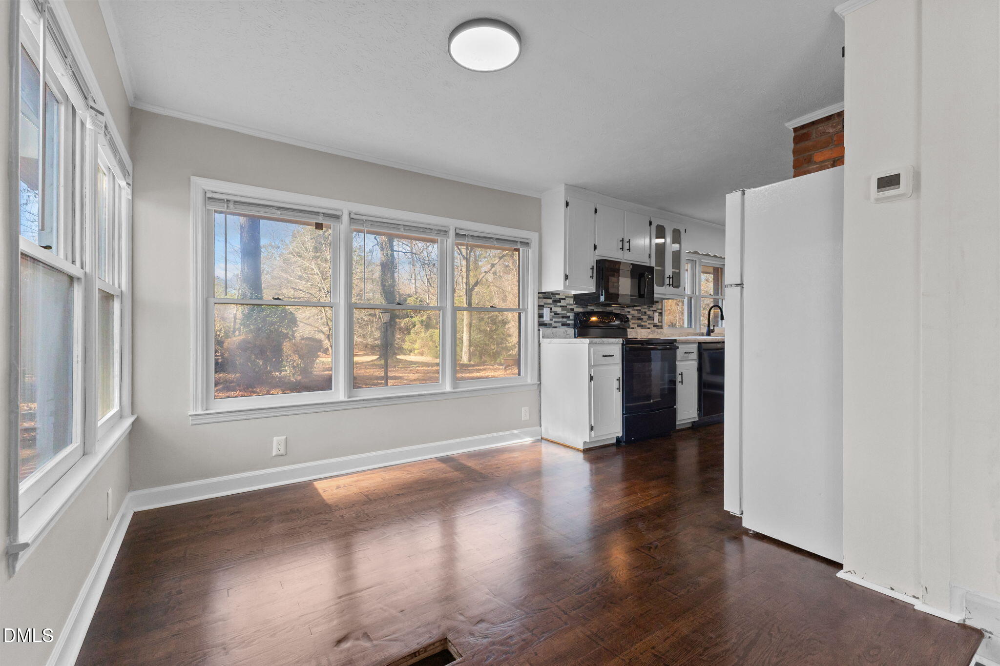 6522 Blake Street Stedman, NC 28391 - Photo 14 of 52 an empty room with wooden floor and a kitchen