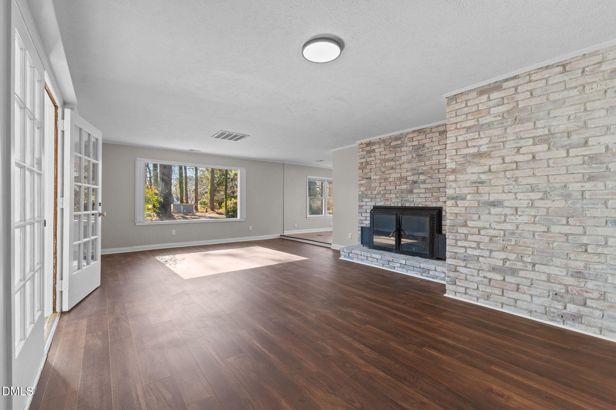 6522 Blake Street Stedman, NC 28391 - Photo 19 of 52 an empty room with windows fireplace and wooden floor