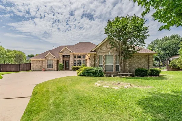 a front view of a house with yard and green space