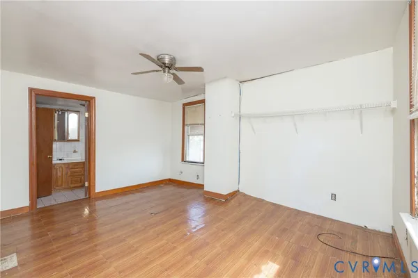 a view of empty room with wooden floor and ceiling fan