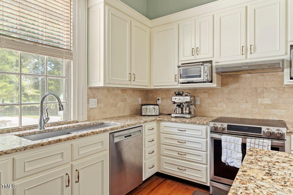 206 Shaver Road Macon, NC 27551 - Photo 30 of 68 a kitchen with granite countertop white cabinets and white appliances