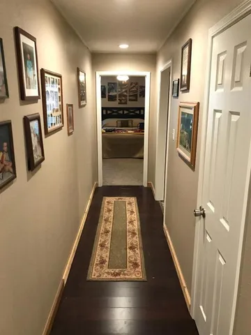a view of a hallway with wooden floor and windows