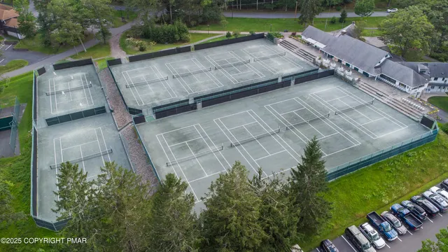 an aerial view of residential houses with outdoor space and trees