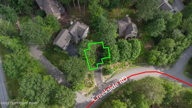 an aerial view of residential houses with outdoor space and trees