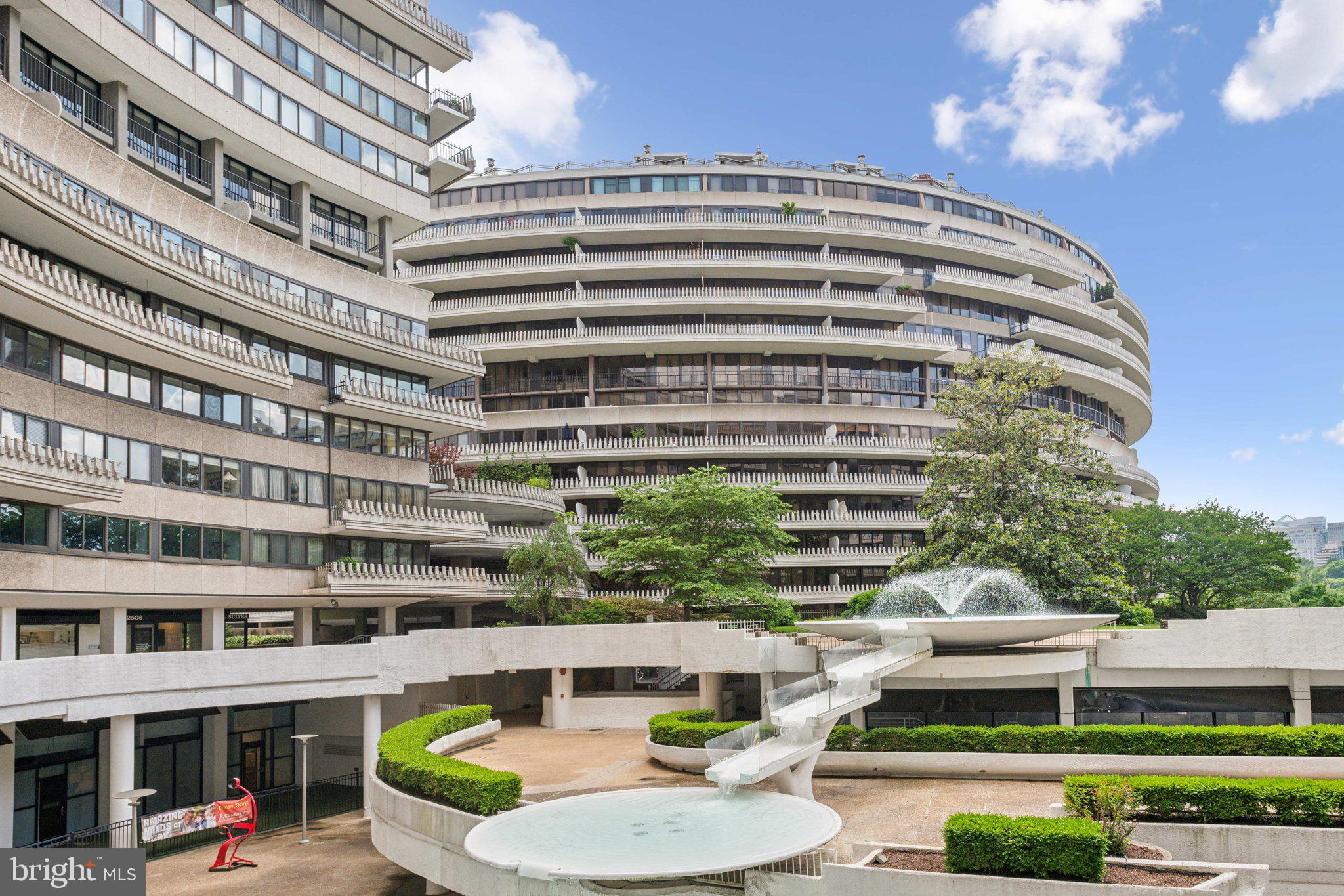2510 Virginia Avenue Northwest, Unit 2BN Washington, DC 20037 - Photo 1 of 21 a view of a tall building with a yard and table and chairs and potted plants