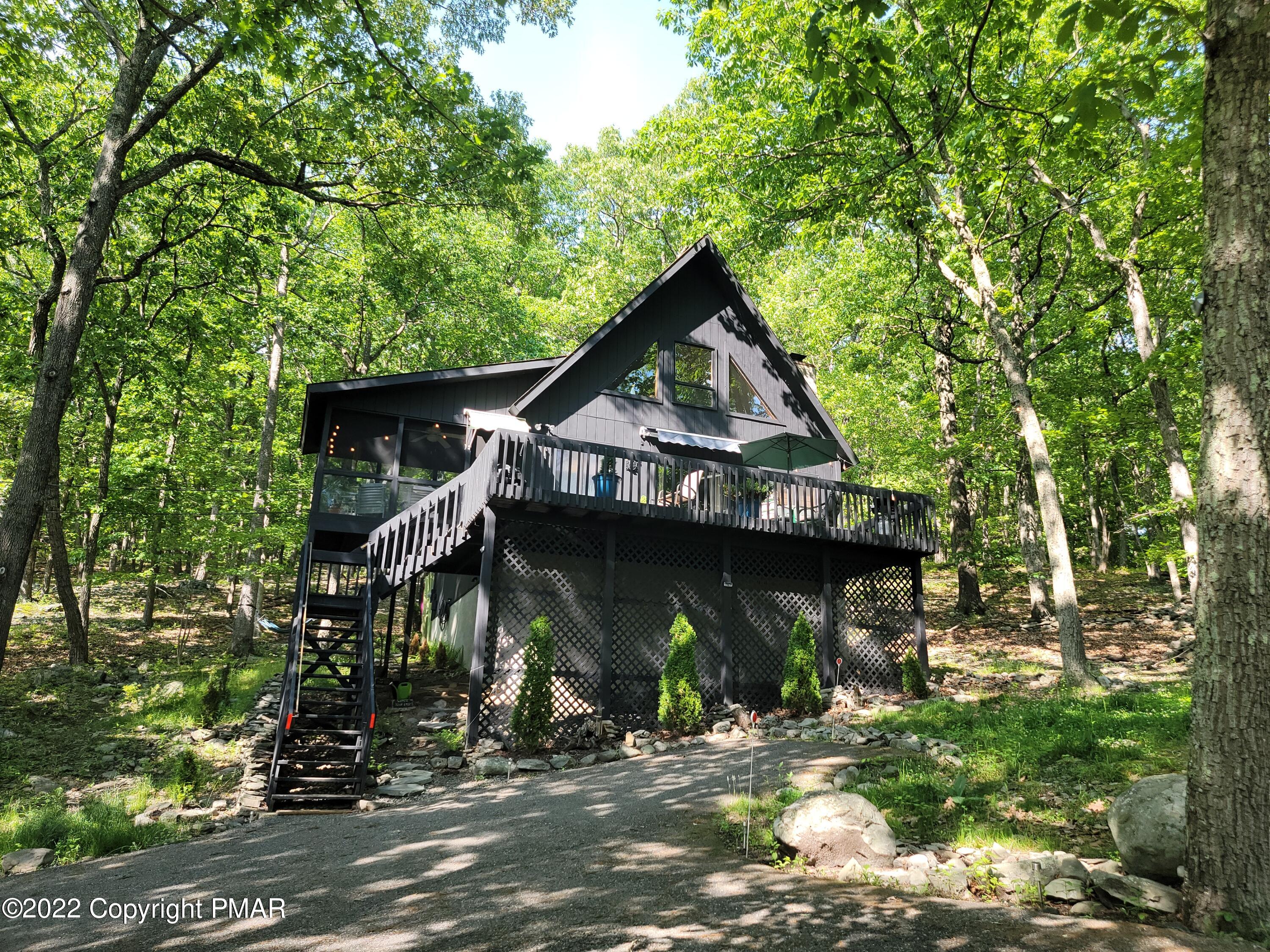 a view of a small house with roof and tree