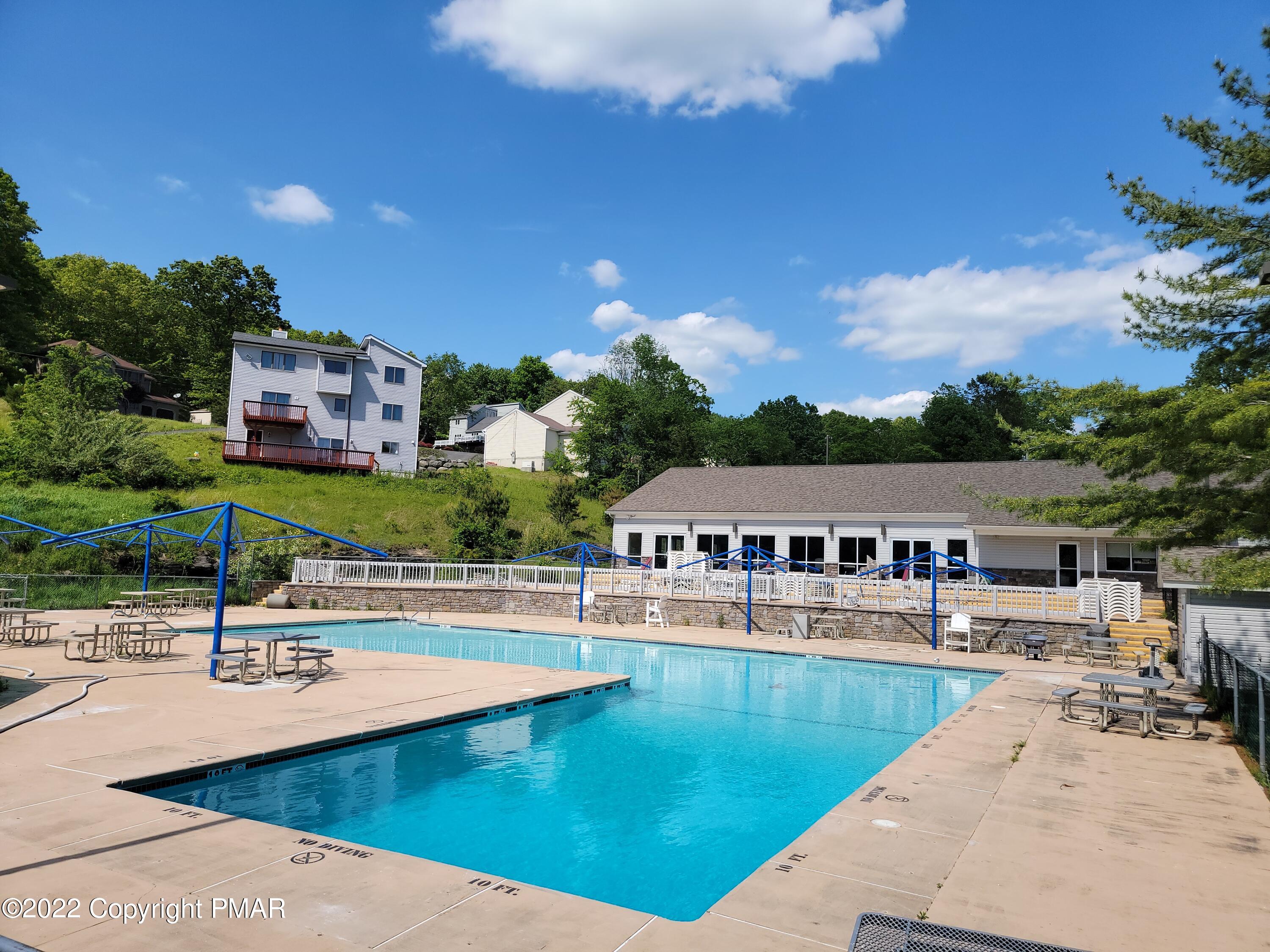 358 Brentwood Drive Bushkill, PA 18324 - Photo 45 of 59 a view of a swimming pool with an outdoor seating and a garden