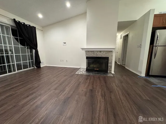 an empty room with wooden floor and a fireplace