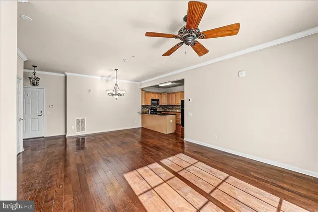 a view of a livingroom with wooden floor and a ceiling fan