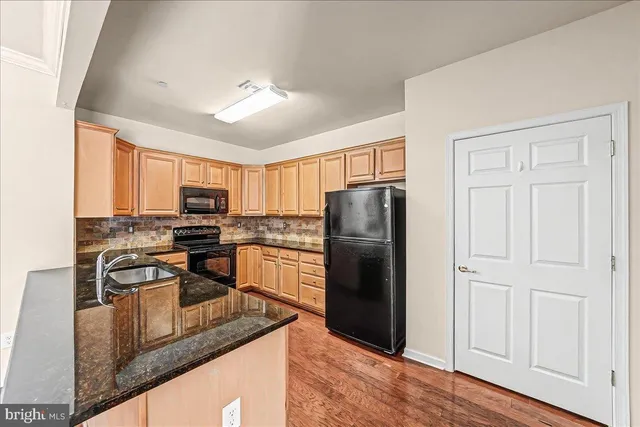 a kitchen with stainless steel appliances granite countertop a refrigerator stove microwave and sink