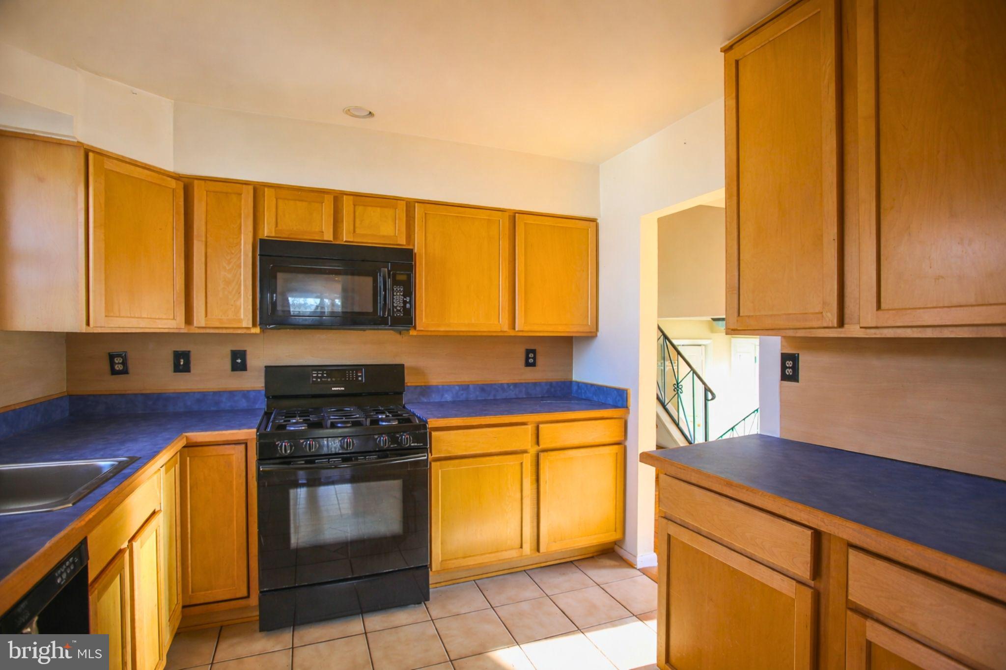 7920 Denton Drive Clinton, MD 20735 - Photo 19 of 34 a kitchen with stainless steel appliances granite countertop a stove a sink and a microwave