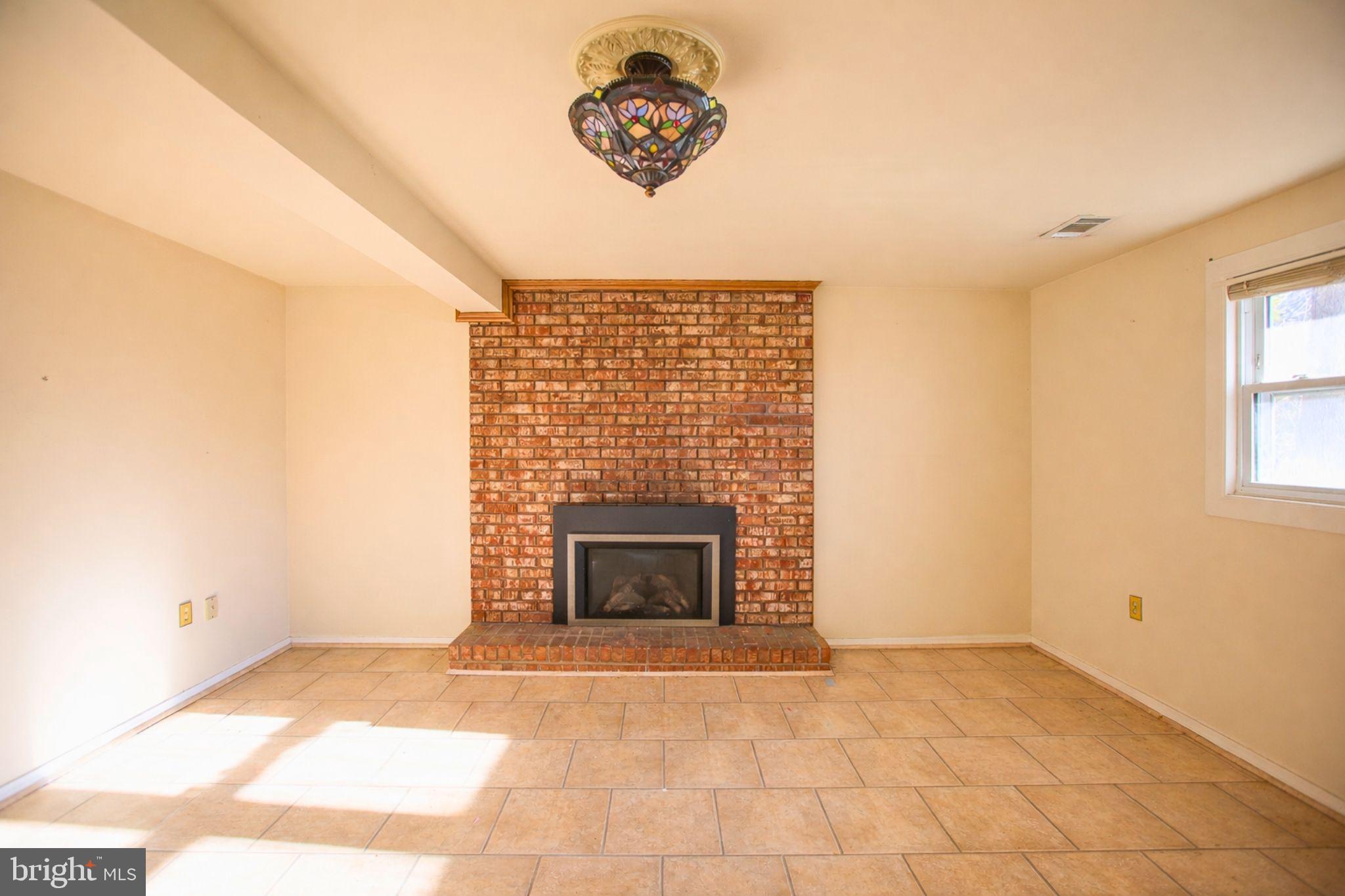 7920 Denton Drive Clinton, MD 20735 - Photo 5 of 34 a view of an empty room with a fireplace and a window
