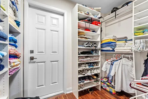 a view of walk in closet with clothes and shoes
