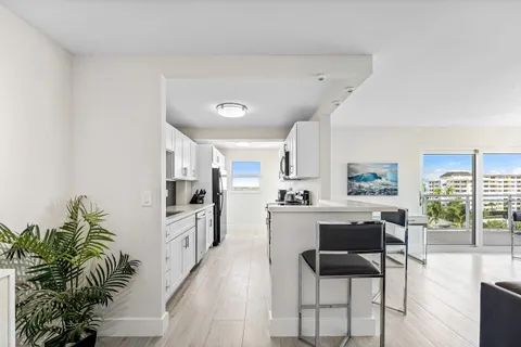 a living room with furniture a large window with kitchen view