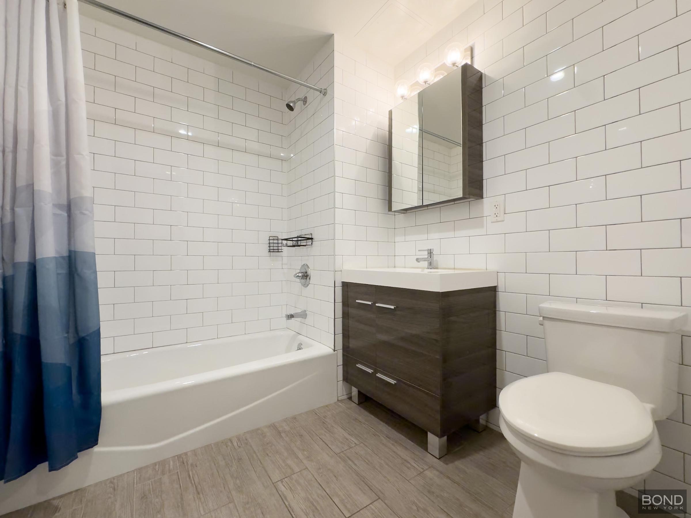 252 Broadway, Unit 4B Brooklyn, NY 11211 - Photo 9 of 9 a bathroom with a sink and a mirror