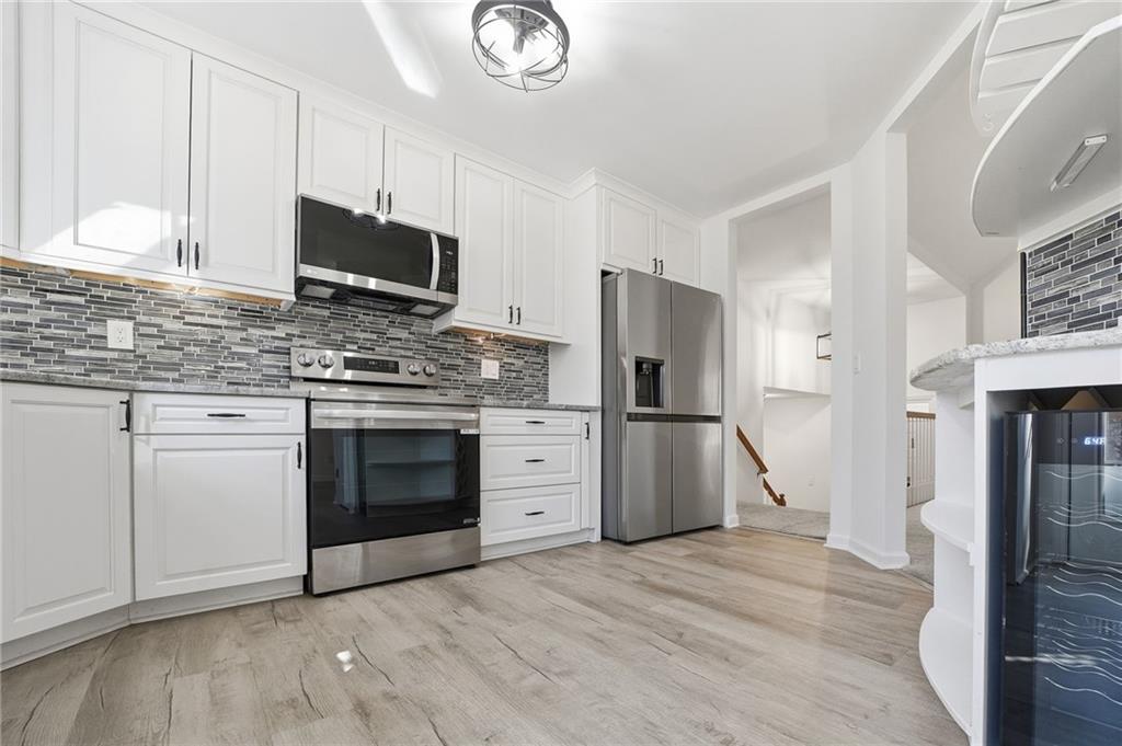 432 Barrel Way Ball Ground, GA 30107 - Photo 12 of 50 a kitchen with stainless steel appliances white cabinets and a stove top oven