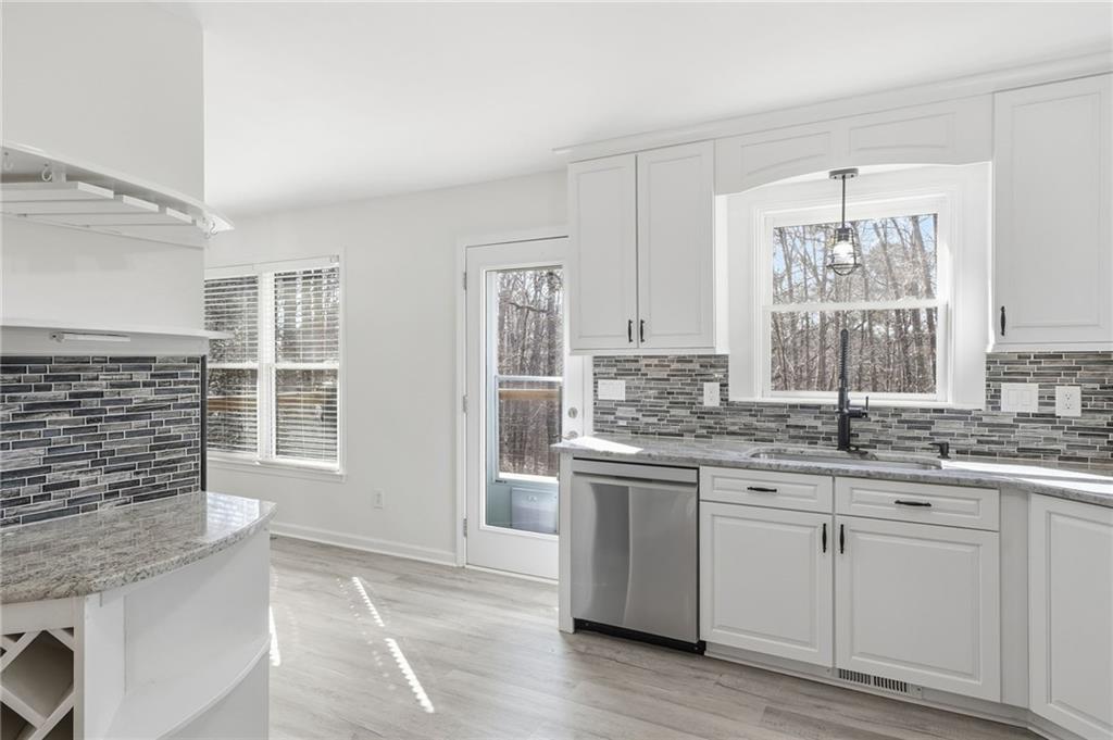 432 Barrel Way Ball Ground, GA 30107 - Photo 14 of 50 a kitchen with stainless steel appliances granite countertop a stove and cabinets