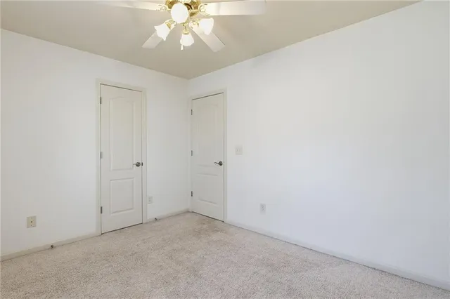 an empty room with a chandelier fan