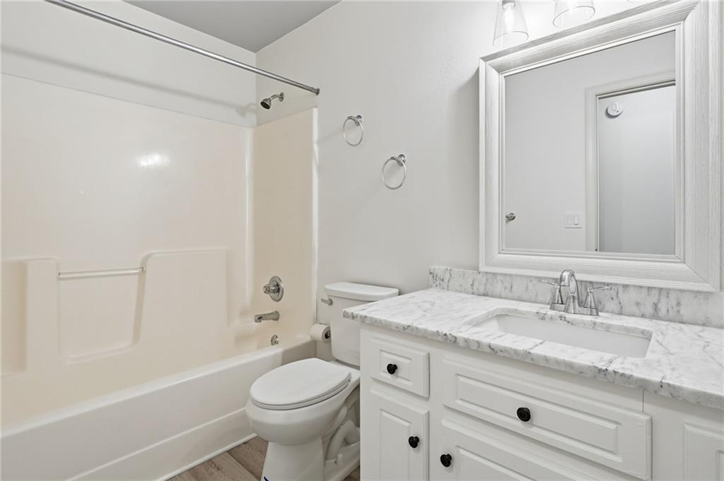 432 Barrel Way Ball Ground, GA 30107 - Photo 28 of 50 a bathroom with a granite countertop toilet a sink and a bathtub