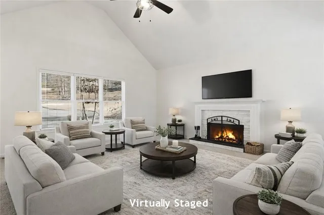 a living room with furniture a fireplace and a flat screen tv