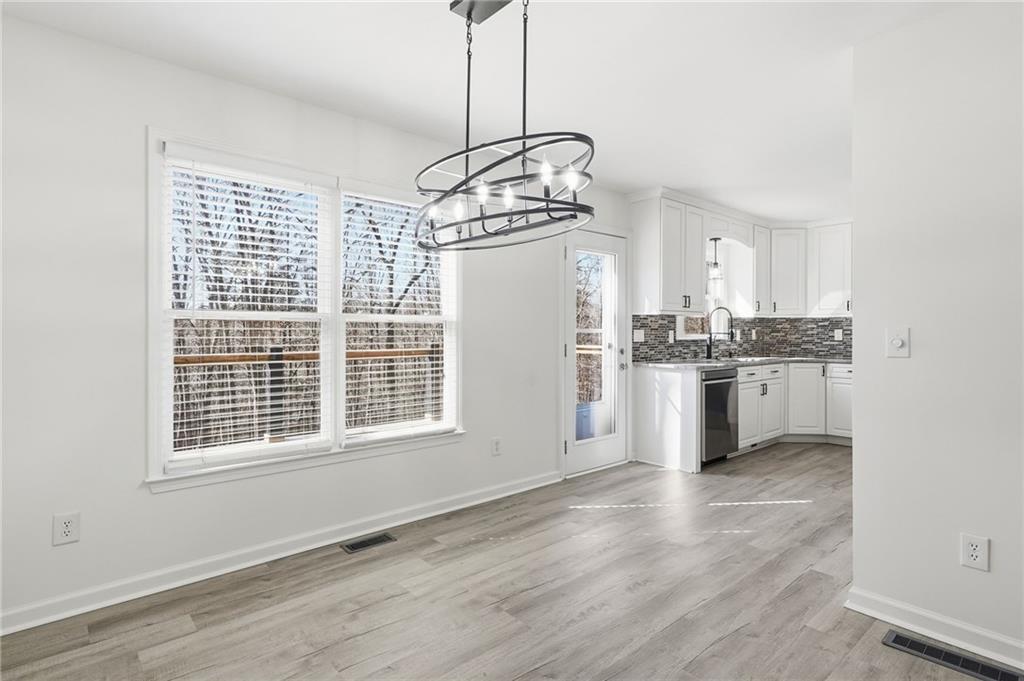 432 Barrel Way Ball Ground, GA 30107 - Photo 9 of 50 a kitchen with stainless steel appliances granite countertop a stove a sink dishwasher a refrigerator and white cabinets with wooden floor