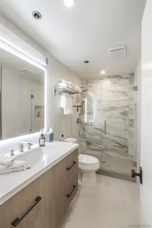 a bathroom with a double vanity sink toilet and shower