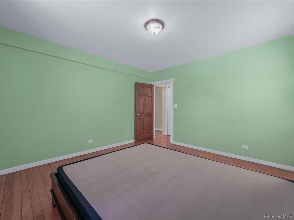 44-05 Macnish Street, Unit 1B Queens, NY 11373 - Photo 11 of 13 Unfurnished bedroom featuring wood-type flooring and baseboards