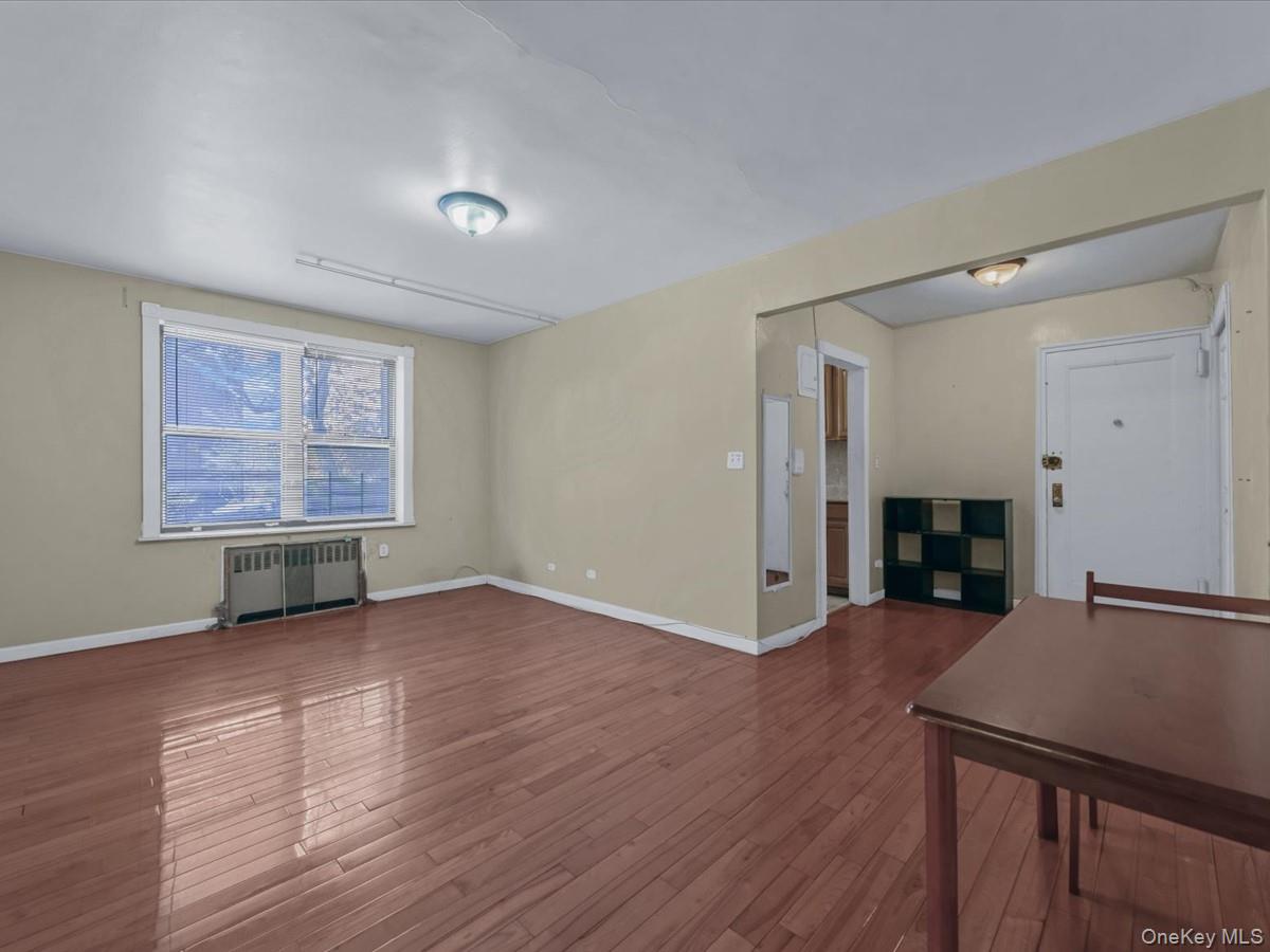 44-05 Macnish Street, Unit 1B Queens, NY 11373 - Photo 7 of 13 Unfurnished living room featuring radiator and hardwood / wood-style floors