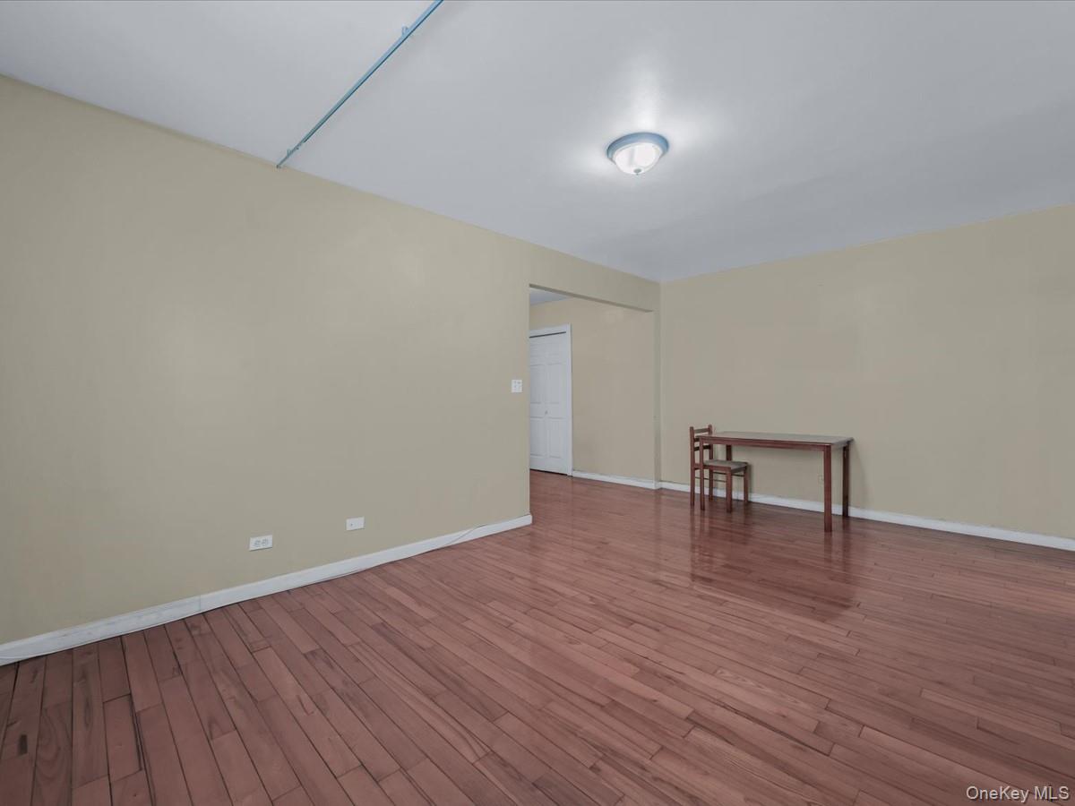 44-05 Macnish Street, Unit 1B Queens, NY 11373 - Photo 8 of 13 Empty room featuring wood finished floors and baseboards