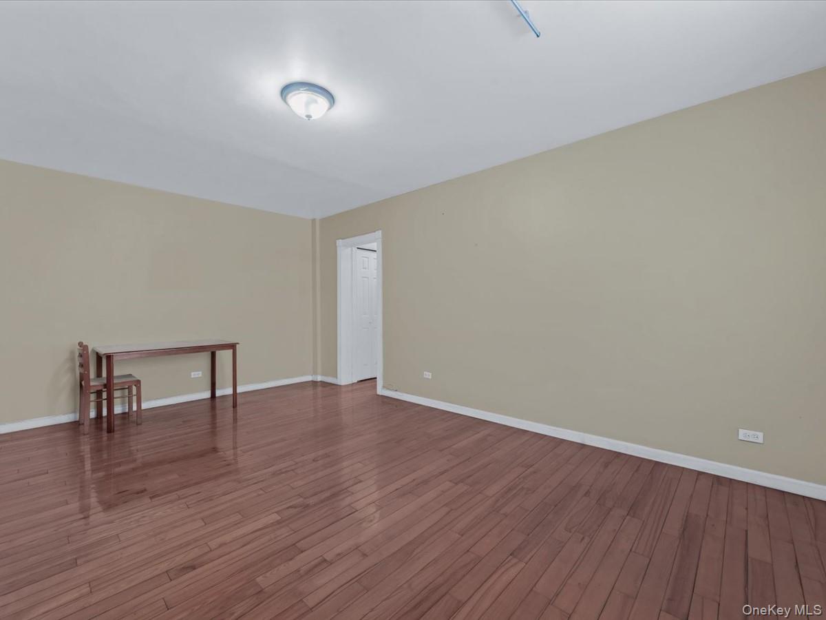 44-05 Macnish Street, Unit 1B Queens, NY 11373 - Photo 9 of 13 Spare room featuring hardwood / wood-style floors and baseboards