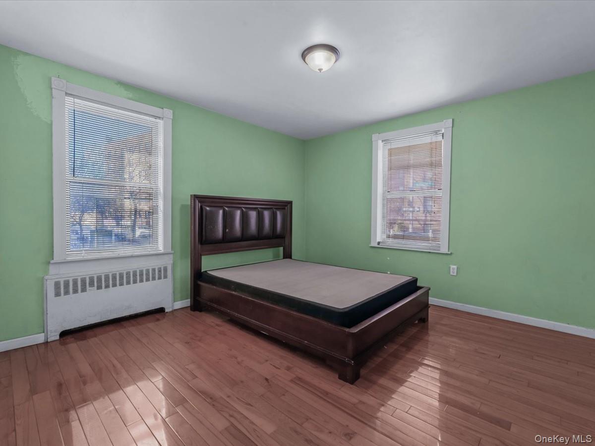 44-05 Macnish Street, Unit 1B Queens, NY 11373 - Photo 10 of 13 Bedroom with radiator and hardwood / wood-style flooring