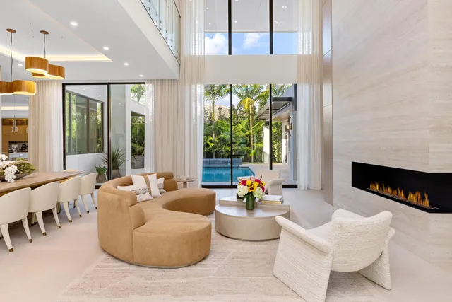 a room with lots of white furniture and a large window