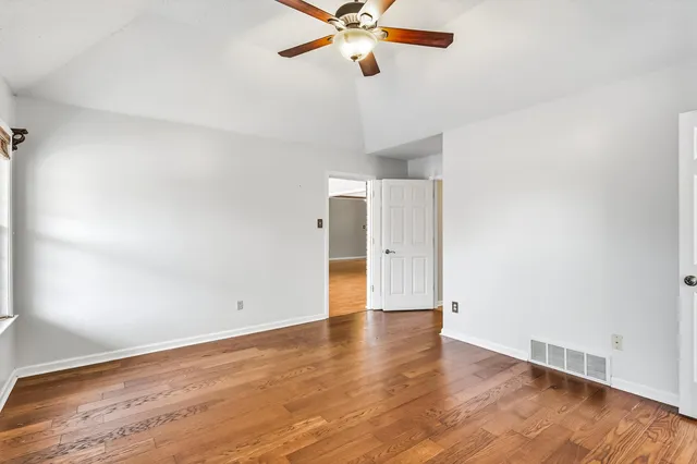 a view of an empty room with wooden floor