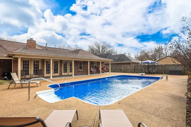a view of a house with swimming pool and sitting area