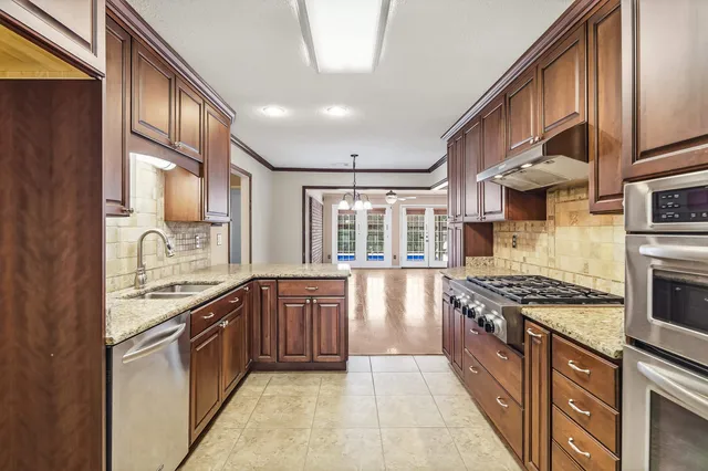 a kitchen with stainless steel appliances granite countertop a stove and a sink