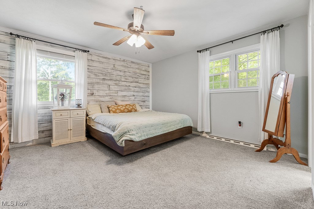 3166 Work Road Ravenna, OH 44266 - Photo 13 of 48 Carpeted bedroom featuring ceiling fan, wooden walls, and multiple windows