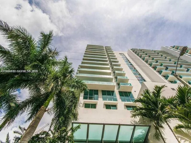 a front view of a multi story building with yard