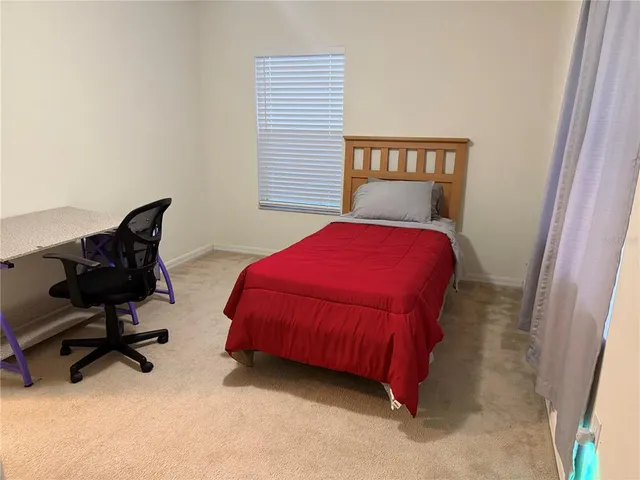 a bedroom with a bed chair and a window