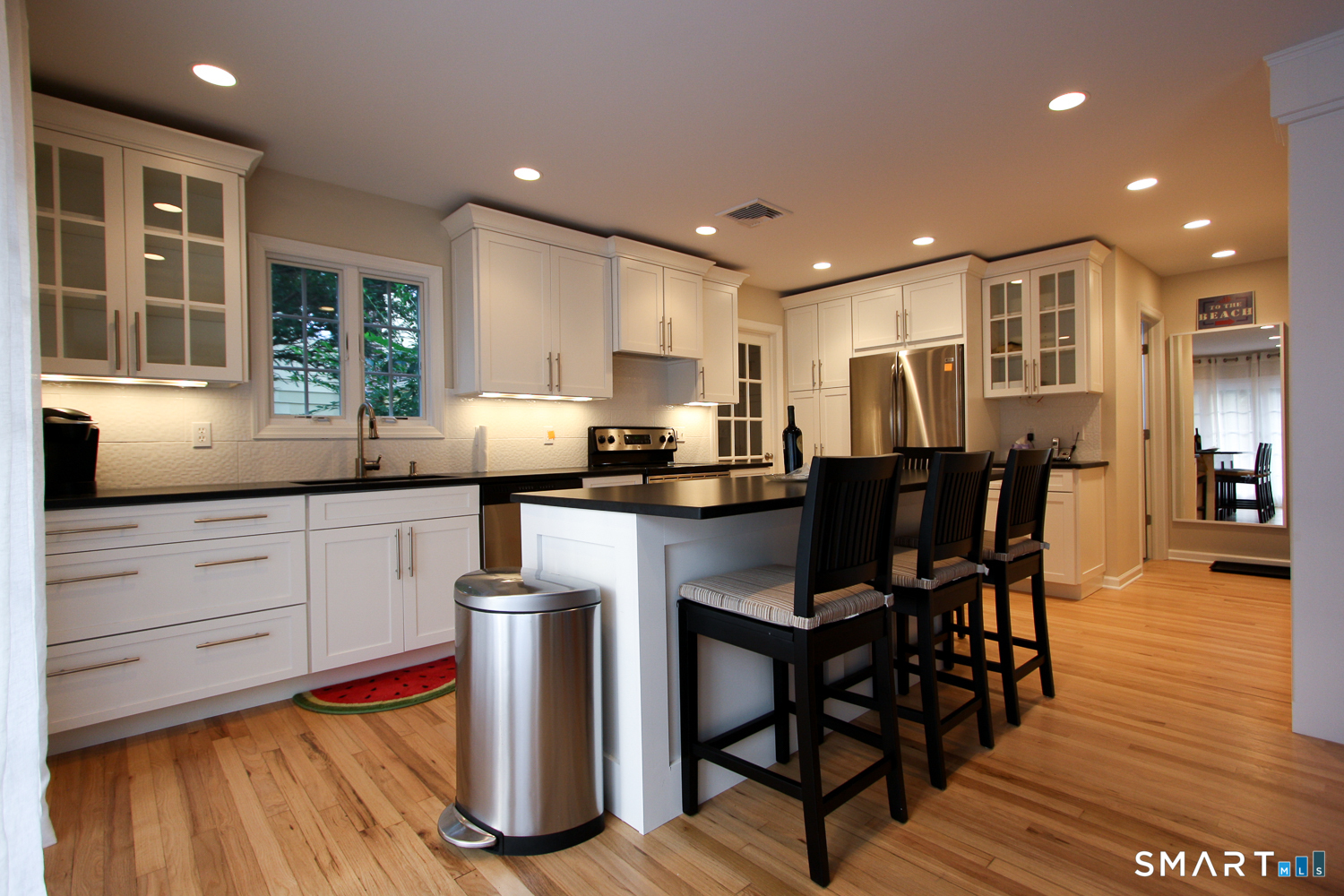 914 South Pine Creek Road, Unit A Fairfield, CT 06824 - Photo 3 of 15 a kitchen with stainless steel appliances granite countertop a stove a refrigerator a kitchen island a table and chairs